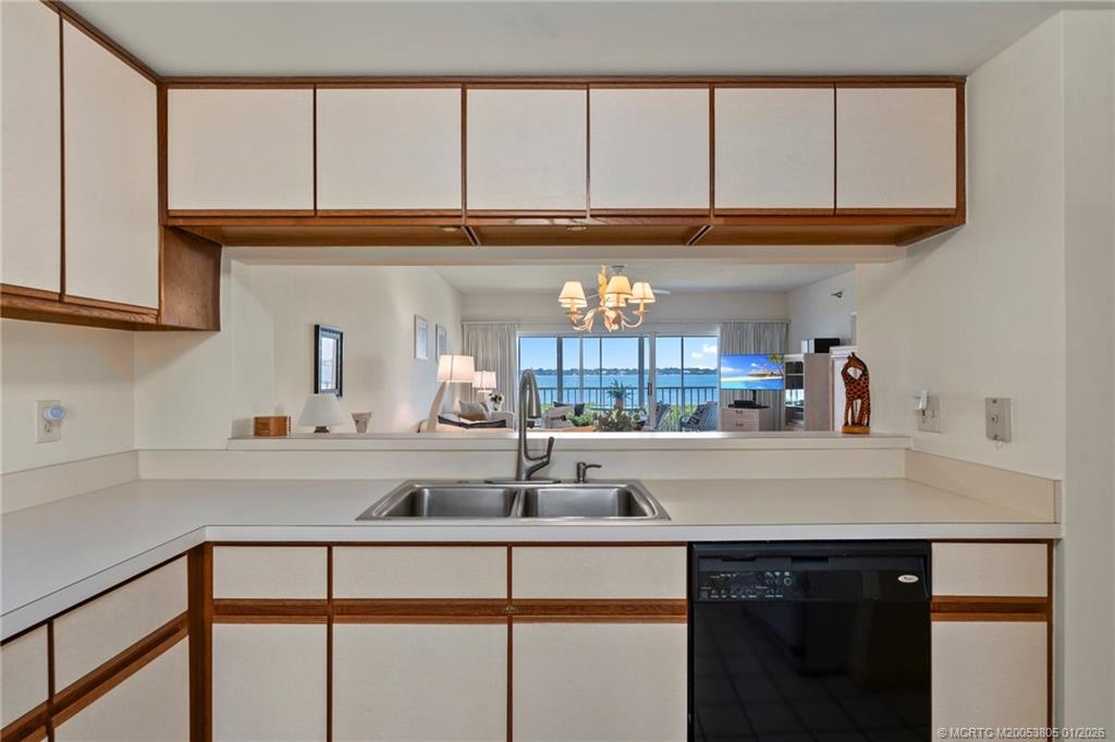 164 Northeast Edgewater Drive, Unit 2105 Jensen Beach, FL 34957 - Photo 11 of 35 a kitchen with a sink cabinets and a window
