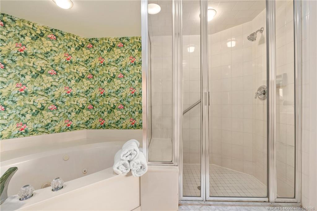164 Northeast Edgewater Drive, Unit 2105 Jensen Beach, FL 34957 - Photo 15 of 35 a bathroom with a bathtub and shower