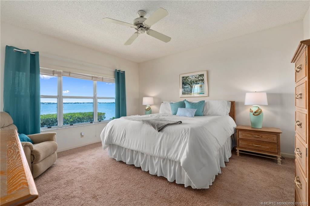 164 Northeast Edgewater Drive, Unit 2105 Jensen Beach, FL 34957 - Photo 18 of 35 a spacious bedroom with a bed and a large window