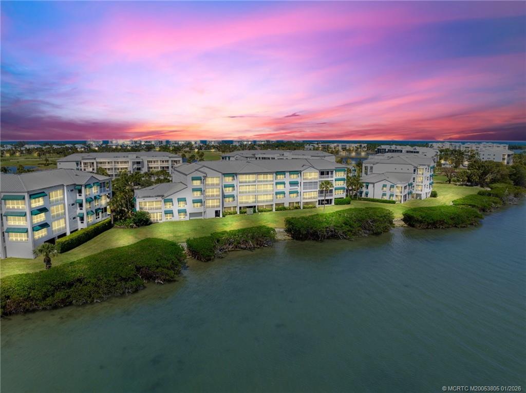 164 Northeast Edgewater Drive, Unit 2105 Jensen Beach, FL 34957 - Photo 3 of 35 a view of a lake with houses in the background