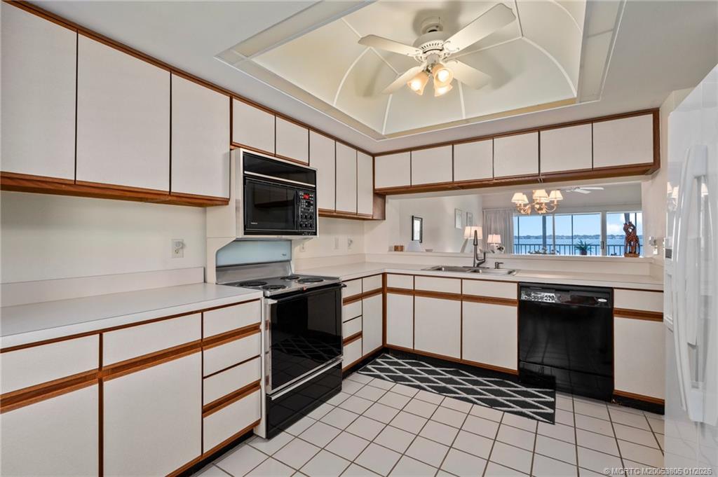 164 Northeast Edgewater Drive, Unit 2105 Jensen Beach, FL 34957 - Photo 9 of 35 a kitchen with stainless steel appliances granite countertop a sink and cabinets