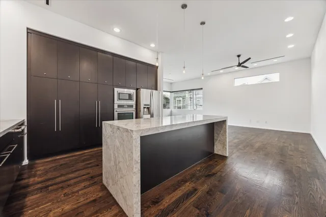 a kitchen with stainless steel appliances kitchen island granite countertop a stove and a refrigerator