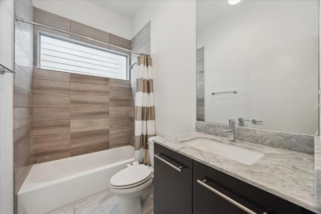 a bedroom with a bed television and a large window