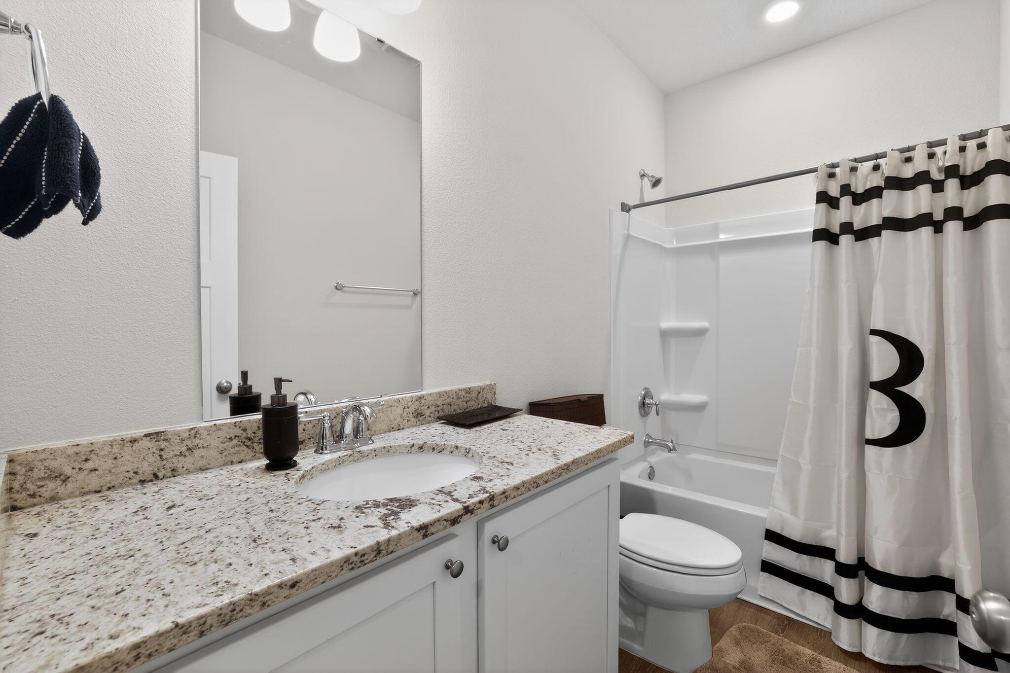 2452 Dakota Way Crestview, FL 32536 - Photo 24 of 29 a bathroom with a granite countertop sink a toilet a mirror and shower
