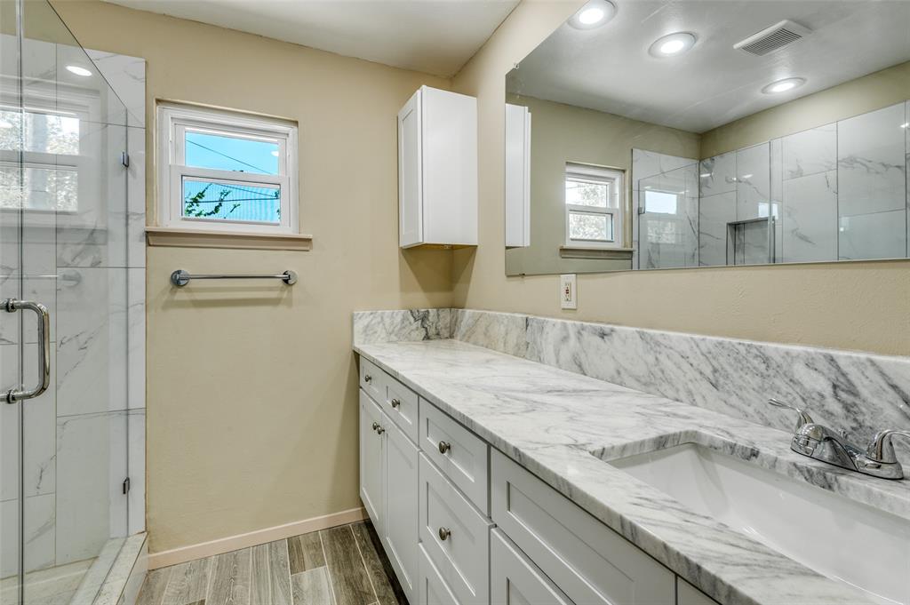 110 Crandall Road Irving, TX 75060 - Photo 7 of 13 a bathroom with a granite countertop sink a mirror and a shower