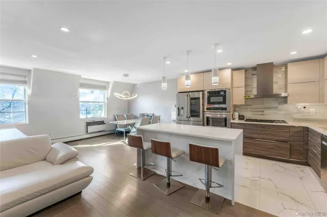a living room with stainless steel appliances kitchen island granite countertop furniture and a large window