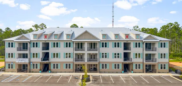 a front view of a residential apartment building with a yard