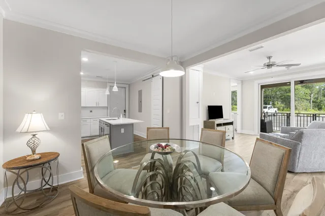 a living room with furniture a large window and dining table