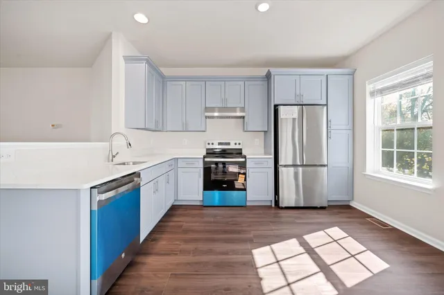 a kitchen with granite countertop a refrigerator and a stove top oven
