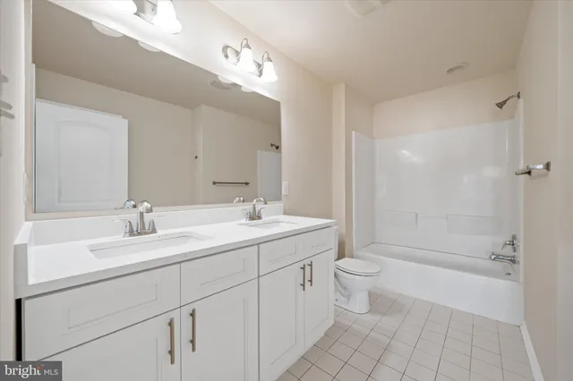 a bathroom with a double vanity sink mirror and toilet