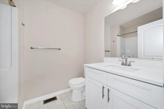 a bathroom with a granite countertop sink a toilet and a mirror