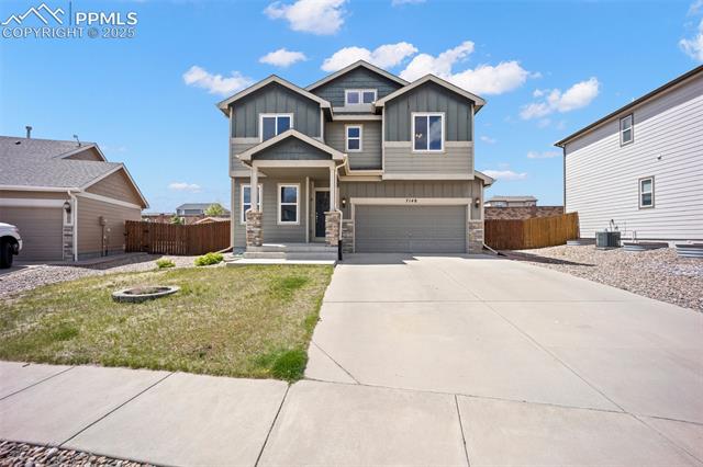 7148 Red Cardinal Loop Colorado Springs, CO 80908 - Photo 3 of 50 Craftsman house featuring board and batten siding, stone siding, concrete driveway, a garage, and central AC unit