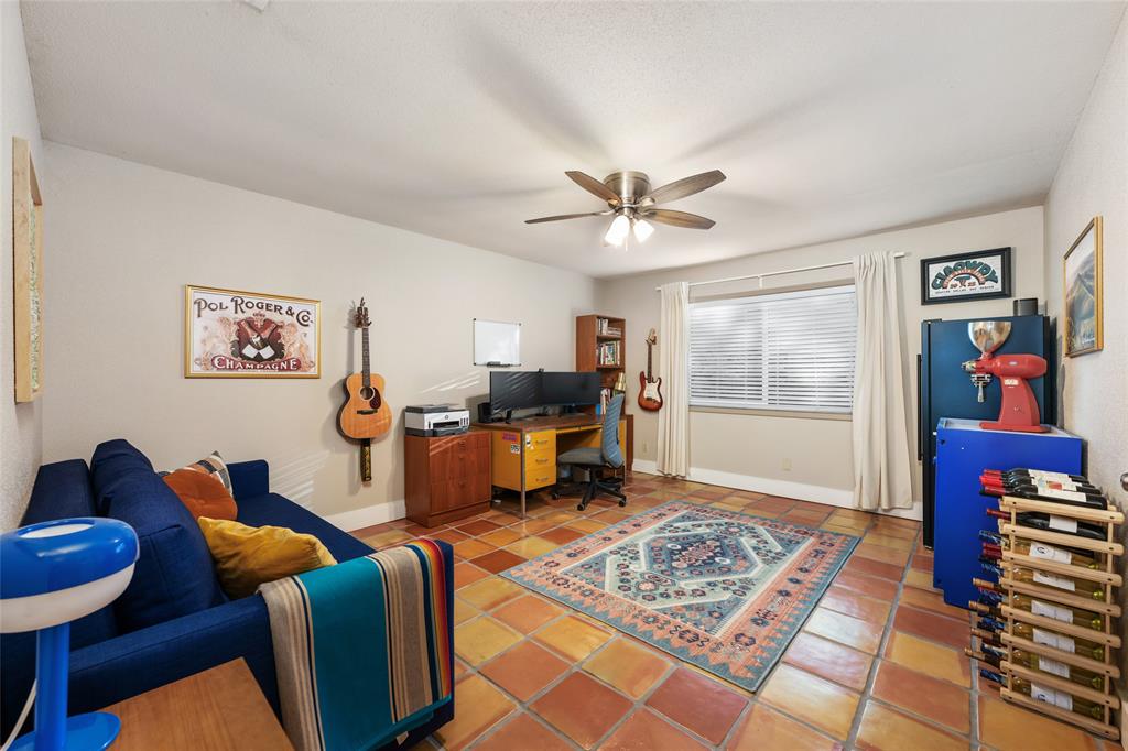 2210 Red Fox Road Austin, TX 78734 - Photo 31 of 40 A versatile living space with a home office setup, adorned with a decorative area rug and terracotta tile flooring.