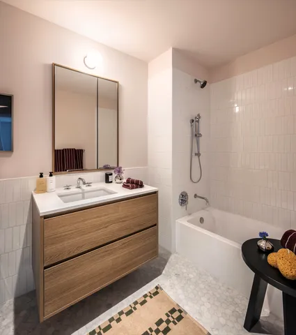 a bathroom with a tub sink and mirror