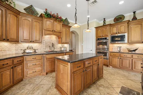 a kitchen with stainless steel appliances granite countertop a stove a sink dishwasher and a refrigerator
