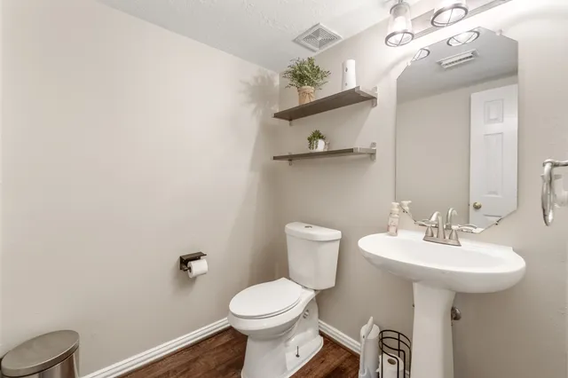 a bathroom with a sink toilet and a mirror