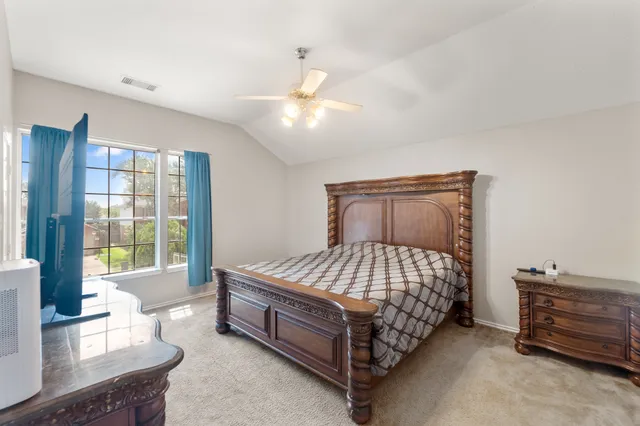 a bed sitting in a bedroom next to a window