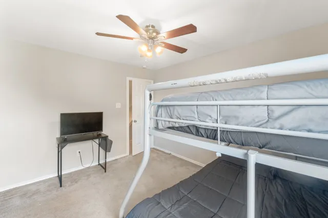 a view of a livingroom with an empty space & a ceiling fan