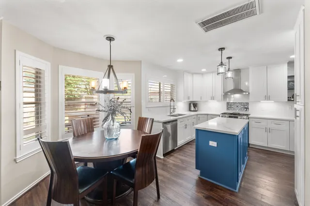 a kitchen with kitchen island granite countertop a sink a center island and cabinets