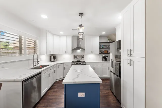 a kitchen with stainless steel appliances granite countertop a sink stove and refrigerator