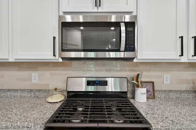 a kitchen with stainless steel appliances kitchen island granite countertop a stove a sink and a refrigerator