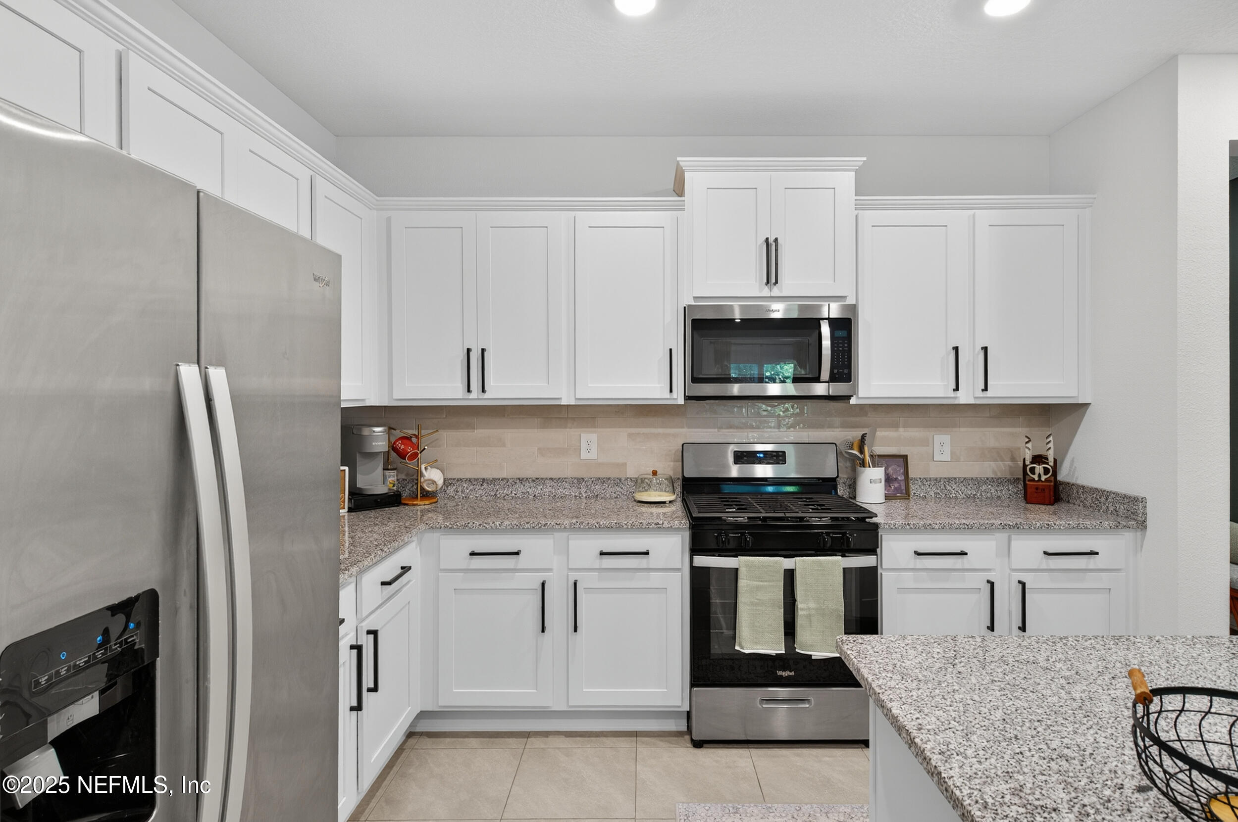 33 Coastline Way St. Augustine, FL 32092 - Photo 17 of 35 a kitchen with stainless steel appliances kitchen island granite countertop a stove a sink and a refrigerator