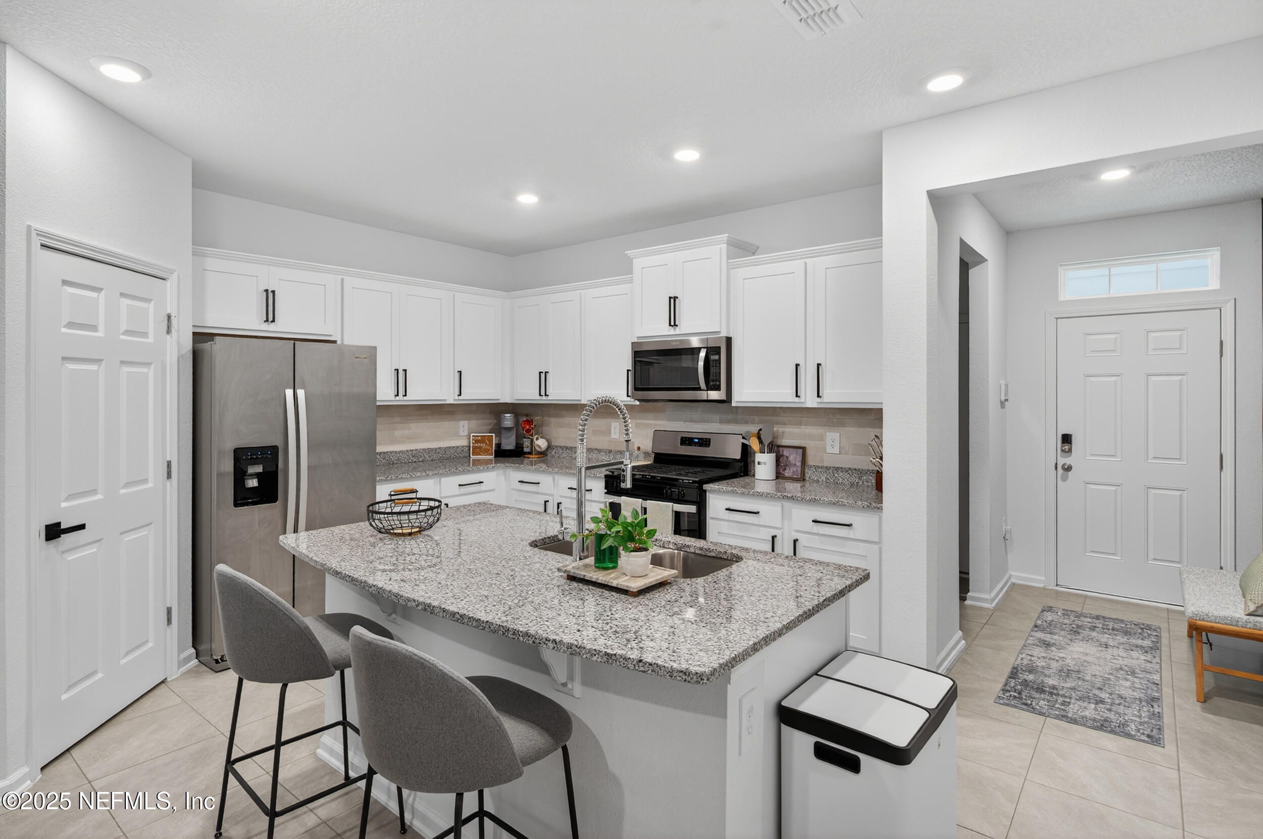33 Coastline Way St. Augustine, FL 32092 - Photo 27 of 35 a kitchen with a refrigerator a stove a sink and white cabinets with wooden floor