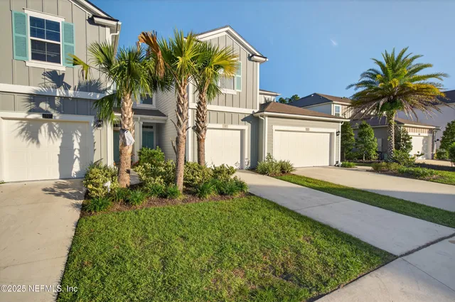 a front view of a house with a garden and yard