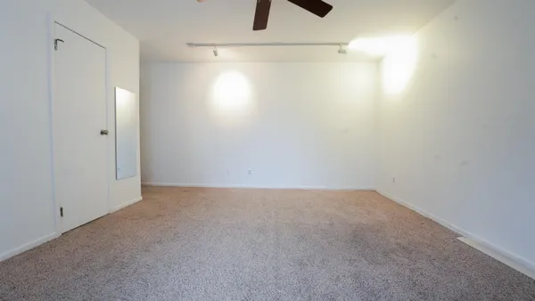 an empty room with window and a ceiling fan