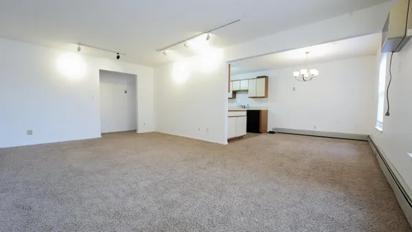 an empty room with windows and cabinet