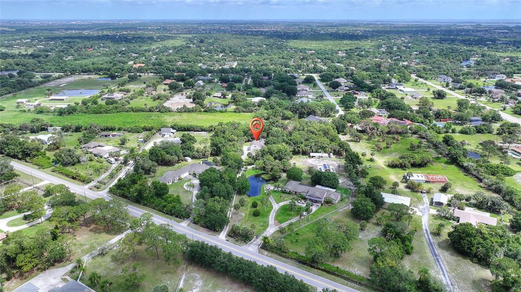 3641 Turtle Mound Road Melbourne, FL 32934 - Photo 69 of 77 an aerial view of green landscape with trees and houses