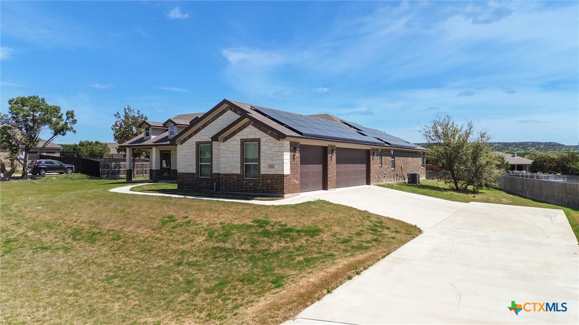 a front view of house with yard and trees in the background