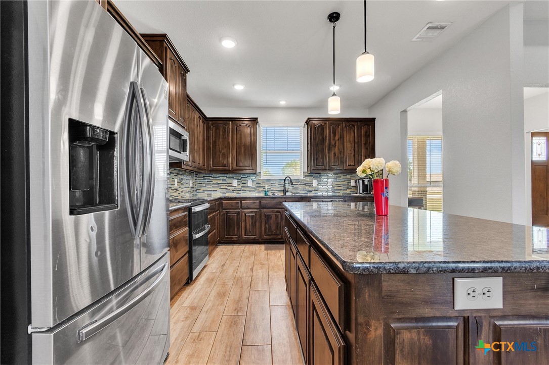 3919 Gracey Lane Kempner, TX 76539 - Photo 11 of 44 a kitchen with stainless steel appliances granite countertop a refrigerator a sink dishwasher a stove and a microwave oven on granite countertops
