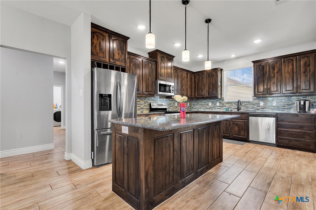 3919 Gracey Lane Kempner, TX 76539 - Photo 12 of 44 a kitchen with stainless steel appliances granite countertop a refrigerator a sink dishwasher a kitchen island a stove and a wooden cabinets