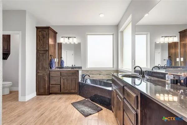 a large bathroom with a double vanity sink a large mirror and a shower