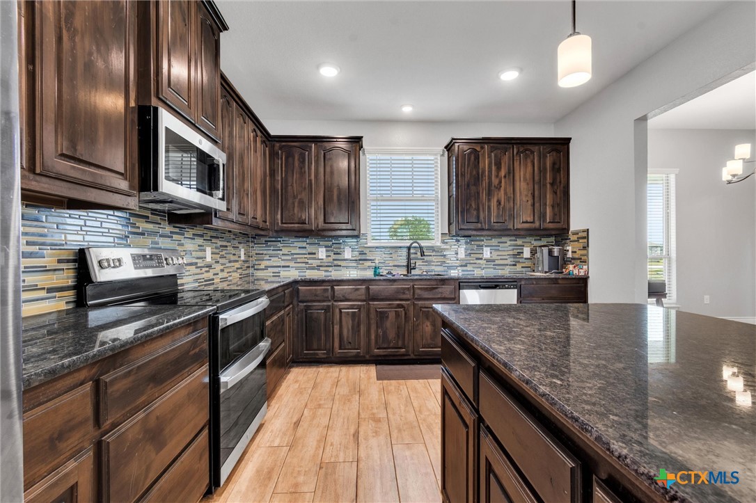 3919 Gracey Lane Kempner, TX 76539 - Photo 19 of 44 a kitchen with stainless steel appliances granite countertop a sink a stove counter space and cabinets