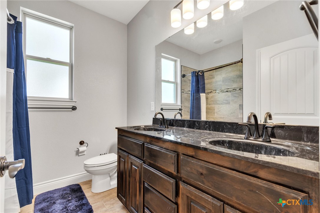 3919 Gracey Lane Kempner, TX 76539 - Photo 27 of 44 a bathroom with a granite countertop sink mirror vanity and toilet