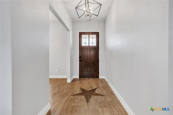 a kitchen with stainless steel appliances granite countertop a refrigerator a sink dishwasher a kitchen island a stove and a wooden cabinets