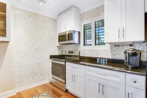 a kitchen with stainless steel appliances granite countertop a stove a sink and a microwave