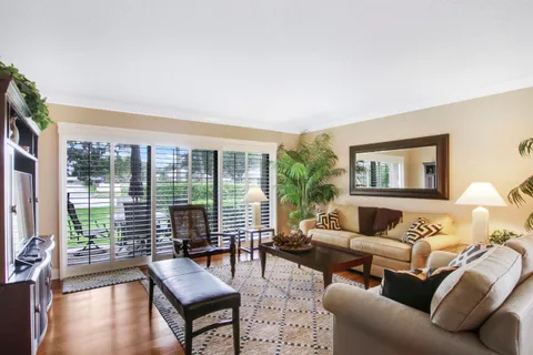 a living room with furniture a flat screen tv and kitchen view