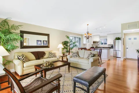 a living room with furniture tv and wooden floor