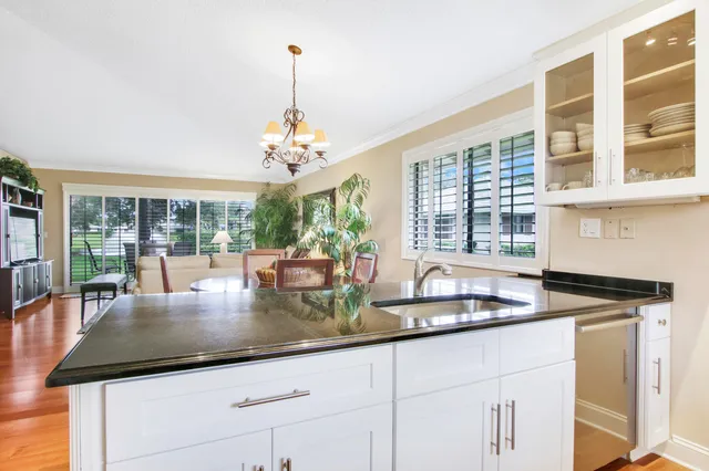 a kitchen with kitchen island granite countertop a large window cabinets and stainless steel appliances