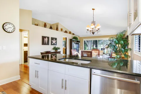 a dining hall with granite countertop a sink and white cabinets