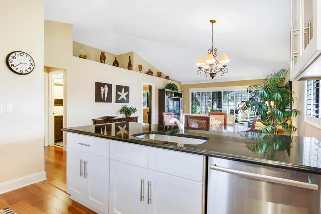 a dining hall with granite countertop a sink and white cabinets