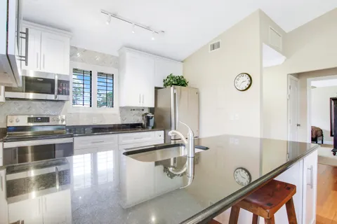 a kitchen that has a sink cabinets counter space and stainless steel appliances
