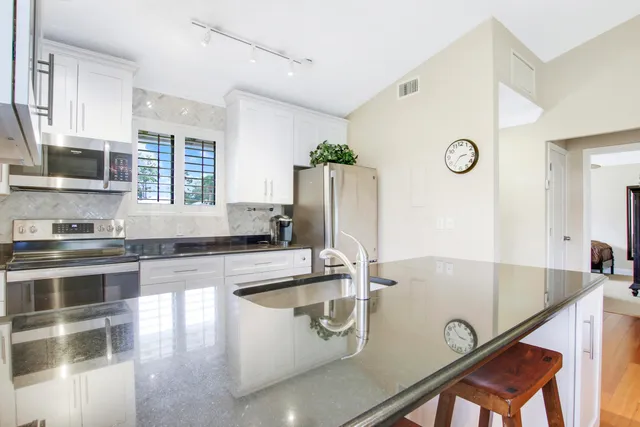 a kitchen that has a sink cabinets counter space and stainless steel appliances