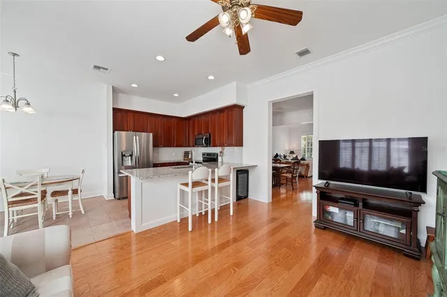 a living room with stainless steel appliances furniture and a flat screen tv