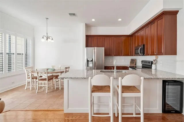 a kitchen with stainless steel appliances kitchen island granite countertop a table and chairs in it