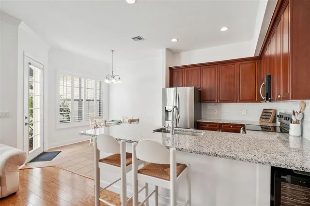 a kitchen with stainless steel appliances granite countertop a sink refrigerator and cabinets