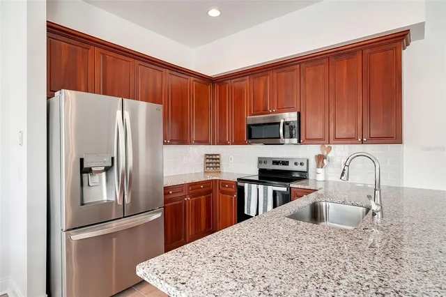 a kitchen with granite countertop a refrigerator stove and microwave